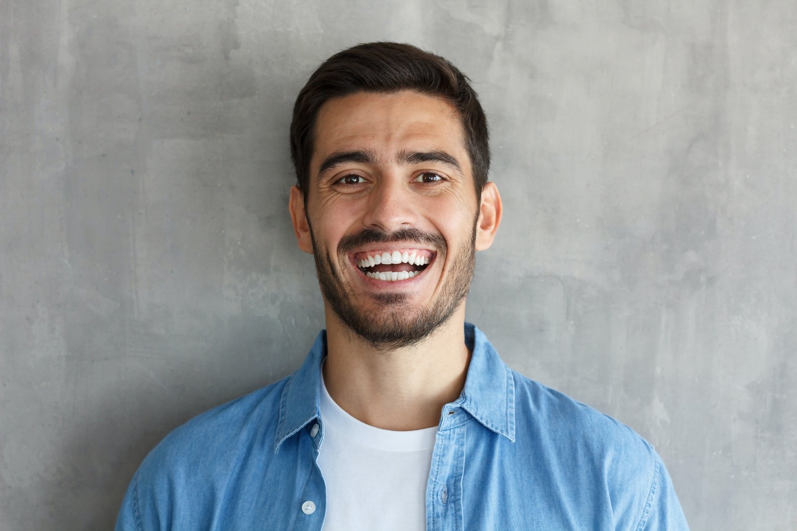 young-man-smiles-broadly-shows-white-perfect-teeth.jpg